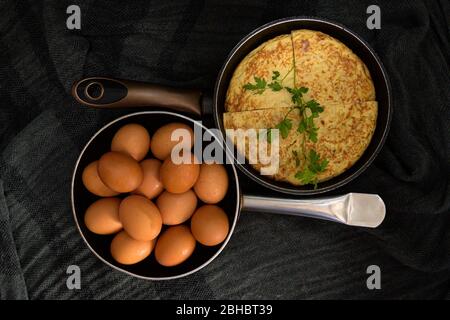 Une prise de gros plan à angle élevé de deux torréfacteurs dans des directions opposées avec des œufs frais et une omelette divisée en quatre parties Banque D'Images