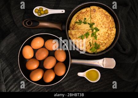 Une vue rapprochée à angle élevé de deux torréfacteurs dans des directions opposées avec des œufs frais et une omelette avec jaune d'œuf et olives sur les côtés Banque D'Images