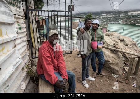 Les habitants du canton d'Imizamo Yethu de Hout Bay boivent de la bière traditionnelle pendant le verrouillage du coronavirus en Afrique du Sud qui interdit la consommation d'alcool Banque D'Images