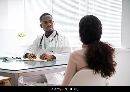 Médecin discutant avec un patient féminin en clinique Banque D'Images