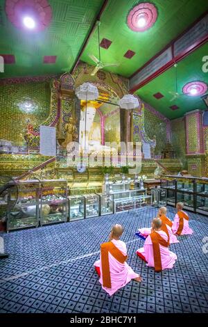 Mandalay, Aungmyaythazan, Myanmar. 24 juillet 2019: Quelques religieuses bouddhistes dans la prière se malaxant devant la statue de Bouddha dans la température de la pagode su Taung Pyae Banque D'Images