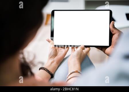 Vue en grand angle des jeunes couples utilisant une tablette numérique ensemble à la maison Banque D'Images