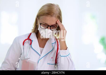 Médecin ou infirmière fatigué épuisé. Éclosion de virus. Pandémie de coronavirus. Personnel médical de la clinique et de l'hôpital travaillant plus d'heures. Professionnel surtravaillé. Banque D'Images