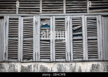 Fenêtres anciennes, usées par le temps. Volets en bois gris. Maison abandonnée. Banque D'Images