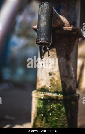 Pompe manuelle pour tirer sous l'eau souterraine en inde. Utilisation de la pompe à eau manuelle dans la rue. Fuite d'eau de la pompe à eau manuelle en inde. Économiser l'eau souterraine. Banque D'Images