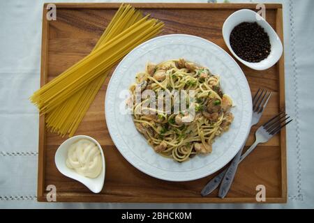 Champignons sur spaghetti . Pâtes spaghetti brutes à l'intérieur d'un bol . Poivre noir, mayonnaise dans un bol. Fourches . Spaghetti non cuits . Délicieux Banque D'Images