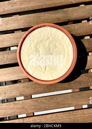 Yaourt maison / yaourt dans un pot d'argile sur une table en bois. Alimentation saine biologique. Banque D'Images