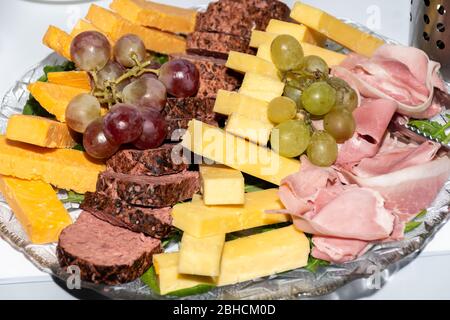 Sélection d'antipasti frais : jambon, fromage, tomates séchées et hors-d'œuvre de viande au vin servis sur une assiette de verre pendant le brunch, le petit déjeuner, le banquet o Banque D'Images