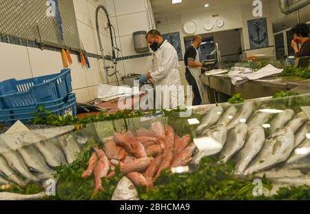 Bruxelles, Belgique. 21 avril 2020. Le vendeur de poissons Mohammad (L) travaille à Bruxelles, Belgique, le 21 avril 2020. Malgré l'impact de la pandémie COVID-19 sur la vie des populations en Belgique, des personnes restent à leur poste pendant le maintien pour fournir à d'autres l'aide et le service. Crédit: Riccardo Pareggiani/Xinhua/Alay Live News Banque D'Images