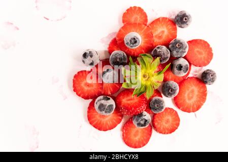 bouquet de fraises et de bleuets mûrs, frais et naturels, coupés en rouge, un fruit sain de printemps et d'été, sur fond blanc Banque D'Images