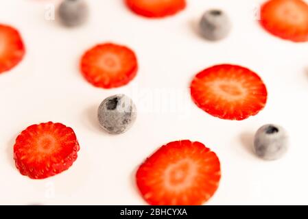 fraises et bleuets mûrs, frais et naturels coupés en rouge, un printemps sain et des fruits d'été, sur fond blanc Banque D'Images