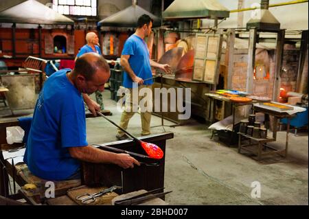 Venise, italie - 20 janvier 2020: Artisan italien glassworker fondre le verre chaud avec traditionnel, blowpipe dans une usine de verre italienne, symbole de l'itali Banque D'Images