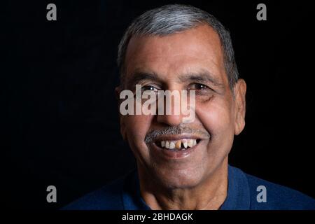 Close-up portrait of happy senior man sur fond noir Banque D'Images