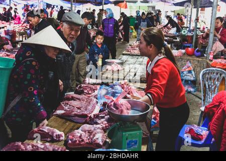 Bac Ha, Vietnam, 7 janvier 2020 - Boucher à bac Ha Market saling la viande crue sur sa table noire en bois Banque D'Images