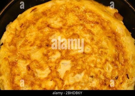 Savoureuse tortilla espagnole dans une poêle. Détail d'une omelette avec œufs, pommes de terre et oignons. Banque D'Images