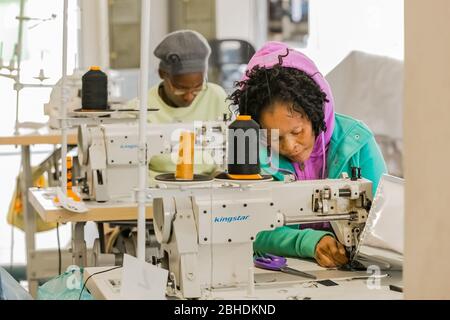 Johannesburg, Afrique du Sud - 2 mai 2017: La femme africaine insiste sur le travail de vêtements faits à la main sur une machine à coudre Banque D'Images