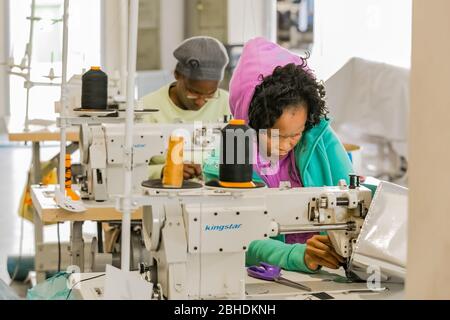 Johannesburg, Afrique du Sud - 2 mai 2017: La femme africaine insiste sur le travail de vêtements faits à la main à l'aide d'une machine à coudre Banque D'Images