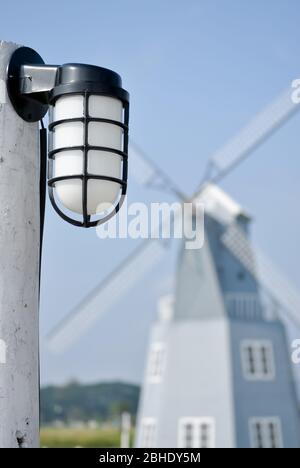 Lampe dans le jardin avec un moulin à vent en arrière-plan. Banque D'Images