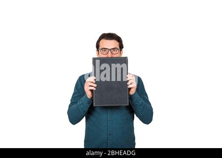 Un homme d'affaires choqué, étonnés par de grands yeux, couvre la bouche en utilisant un porte-documents, cachant l'expression faciale, isolé sur fond blanc. Affaires W Banque D'Images