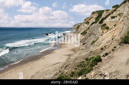 Plage de falaises au Rhode Island : les vagues de l'océan se brisent sur une plage de sable sous les hautes falaises de Block Island, RI. Banque D'Images