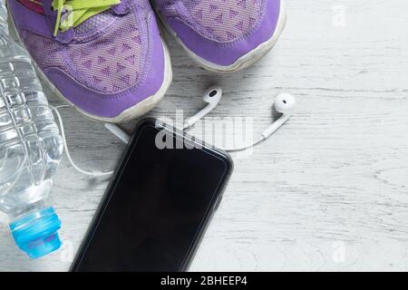 Télévision Sport Chaussures violet laïcs, smartphone et sur les équipements d'entraînement en bois blanc avec fond copyspace pour votre texte. Concept de vie sain et Banque D'Images