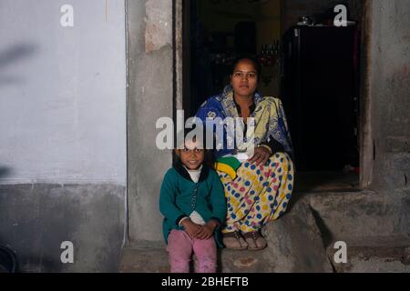 mère rurale indienne et fille assise à la porte de la maison Banque D'Images