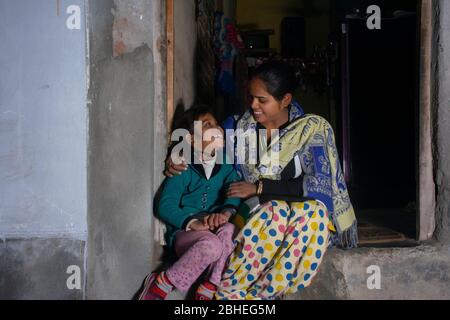 mère rurale indienne et fille assise à la porte de la maison Banque D'Images