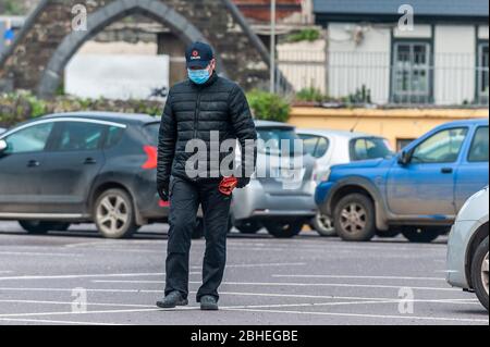 Skibbereen, West Cork, Irlande. 25 avril 2020. Un homme marche à Skibbereen tout en portant un masque de protection et des gants pour se protéger contre Covid-19. Crédit: AG News/Alay Live News Banque D'Images