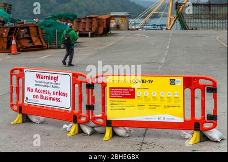 Union Hall, West Cork, Irlande. 25 avril 2020. Un pêcheur marche vers son bateau sur Union Hall Quay en passant par les panneaux d'avertissement de ne pas entrer à moins que dans les affaires. Crédit: AG News/Alay Live News Banque D'Images