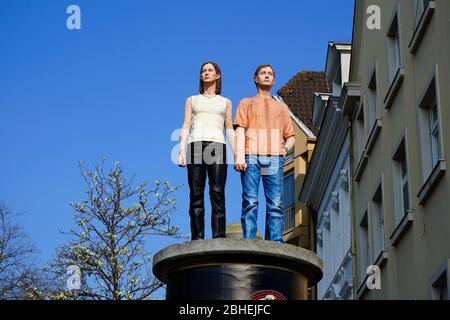 Ce qu'on appelle 'Säulenheilige' (sculptures réalistes sur les piliers publicitaires). Artiste: Christoph Pöggeler. Emplacement : Düsseldorf, Burgplatz, vieille ville. Banque D'Images