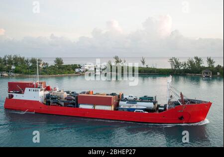 Vue tôt le matin d'un cargo chargé qui passe le long de Paradise Island à l'intérieur du port de Nassau (Bahamas). Banque D'Images