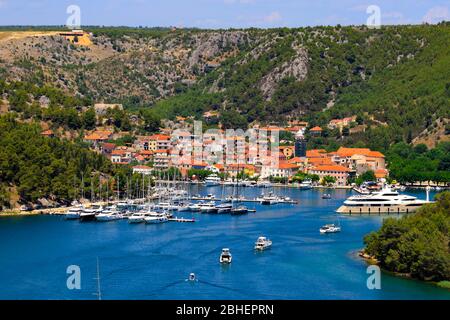 Paysage d'été de la petite ville croate Skradin sur la rivière Krka près du parc national de Krka. Beaux yachts et bâtiments orange Banque D'Images