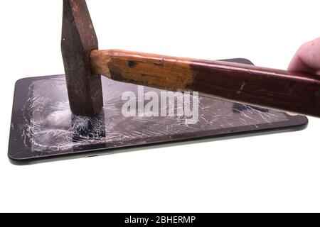 Un marteau frappe sur un écran de tablette, une tablette est détruite Banque D'Images