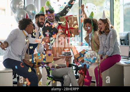 célébration de l'anniversaire d'une collègue féminine au travail. surprise, célébration, affaires décontractées Banque D'Images