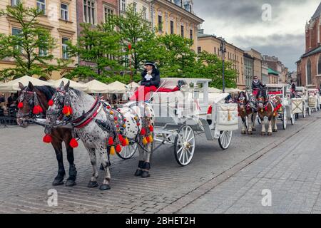 Voitures d'équitation sur la place principale de Cracovie Banque D'Images