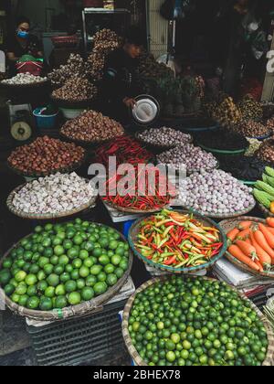 Hanoi, Vietnam, Febuary 1, 2020 - légumes frais à vendre sur le marché de la nourriture de rue dans la vieille ville. Ail, citron, Ananas, oignons, peper, chilis rouges Banque D'Images