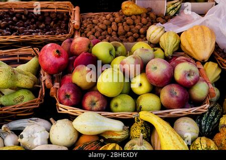 De nombreux paniers de pommes, de poires, de châtaignes, de noix, de citrouilles, de fruits et de légumes sur un marché agricole stallant dans le Piémont, en Italie Banque D'Images