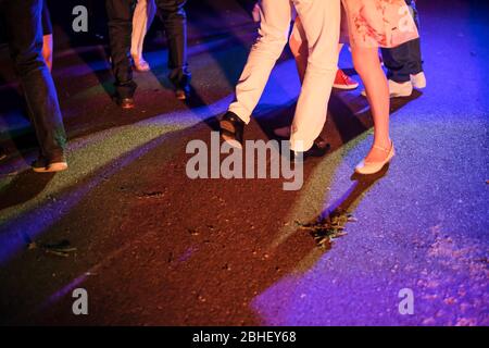 Les pieds de jeunes dansant à la fête à l'extérieur le soir, Banque D'Images