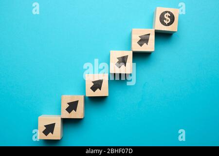 Concept de croissance du dollar américain et avec des icônes sur des blocs de bois. Gros plan. Banque D'Images