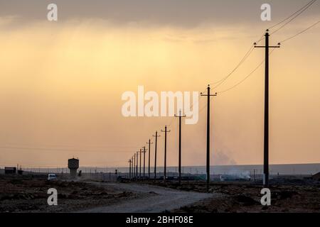 Rangée de poteaux d'électricité et une tour d'eau, sur le grand et sec paysage près de Jiayuguan, non loin de l'extrémité orientale de la Grande Muraille, Gansu, Chin Banque D'Images