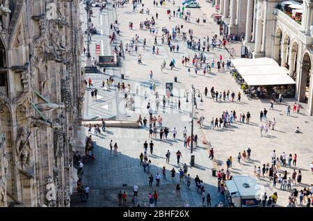 Milan, Italie, 9 septembre 2018 : foule de petites figures de nombreuses personnes marchent sur la place Piazza del Duomo près de la galerie Vittorio Emanuele II dans le centre historique de la ville, vue de dessus de la cathédrale de Milan Banque D'Images