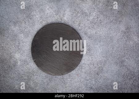 Vider le plateau rond en ardoise sur le gris Banque D'Images