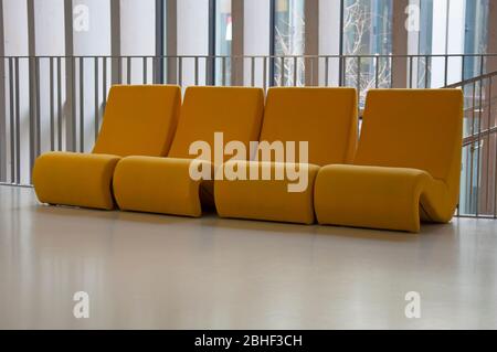 Quatre chaises confortables jaunes dans le hall du musée de la vigne, sol blanc brillant. Bordeaux, France Banque D'Images