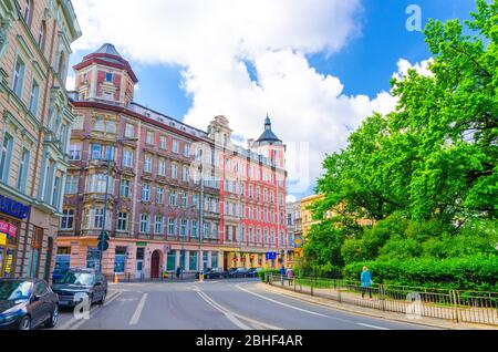 Wroclaw, Pologne, 7 mai 2019: Rue de la ville avec des bâtiments de plusieurs étages près de plac Square parc St. Matthias avec des arbres verts, fond bleu ciel Banque D'Images