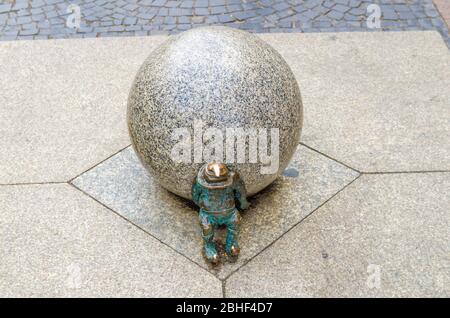 Wroclaw, Pologne, 7 mai 2019: Le nain pousse le ballon de marbre, célèbre nain miniature en bronze avec une sculpture de chapeau est un symbole de Wroclaw dans le vieux centre historique de la ville Banque D'Images