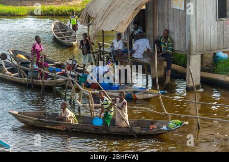 Ganvie village scène avec les gens qui obtiennent de l'eau potable pour leurs maisons d'un approvisionnement en eau propre. C'est un village unique construit sur pilotis, sur le lac NOK Banque D'Images