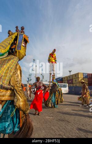 Spectacle culturel avec danses et homme sur pilotis dans le port de Lomé, Togo. Banque D'Images