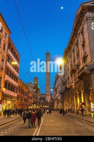 Bologne, Italie, 17 mars 2019: Beaucoup de gens marchant dans la rue vers deux tours médiévales de Bologne le due Torri: Asinelli et Garisenda dans le vieux centre historique de la ville le soir, Emilie-Romagne Banque D'Images