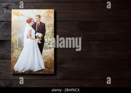 Imprimé toile photo. Décoration murale. Exemple de photographie de mariage étirée avec galerie. Portrait de la mariée suspendu sur fond brun en bois. Avant v Banque D'Images