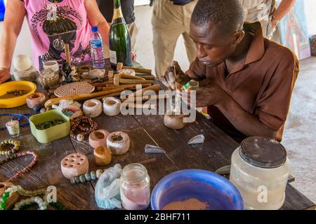 Homme arrangeant la poussière de verre pour faire des perles à l'usine de perles de Cedi près d'Accra, Ghana. Banque D'Images